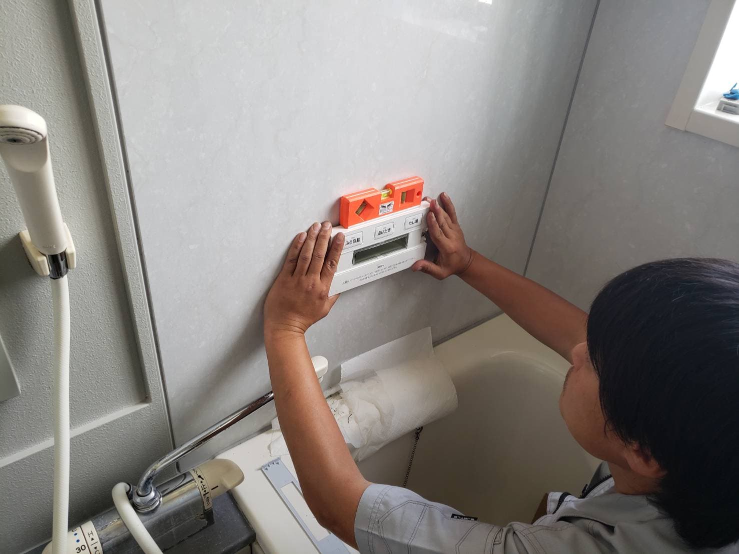 水平器で取付位置を確認する作業員